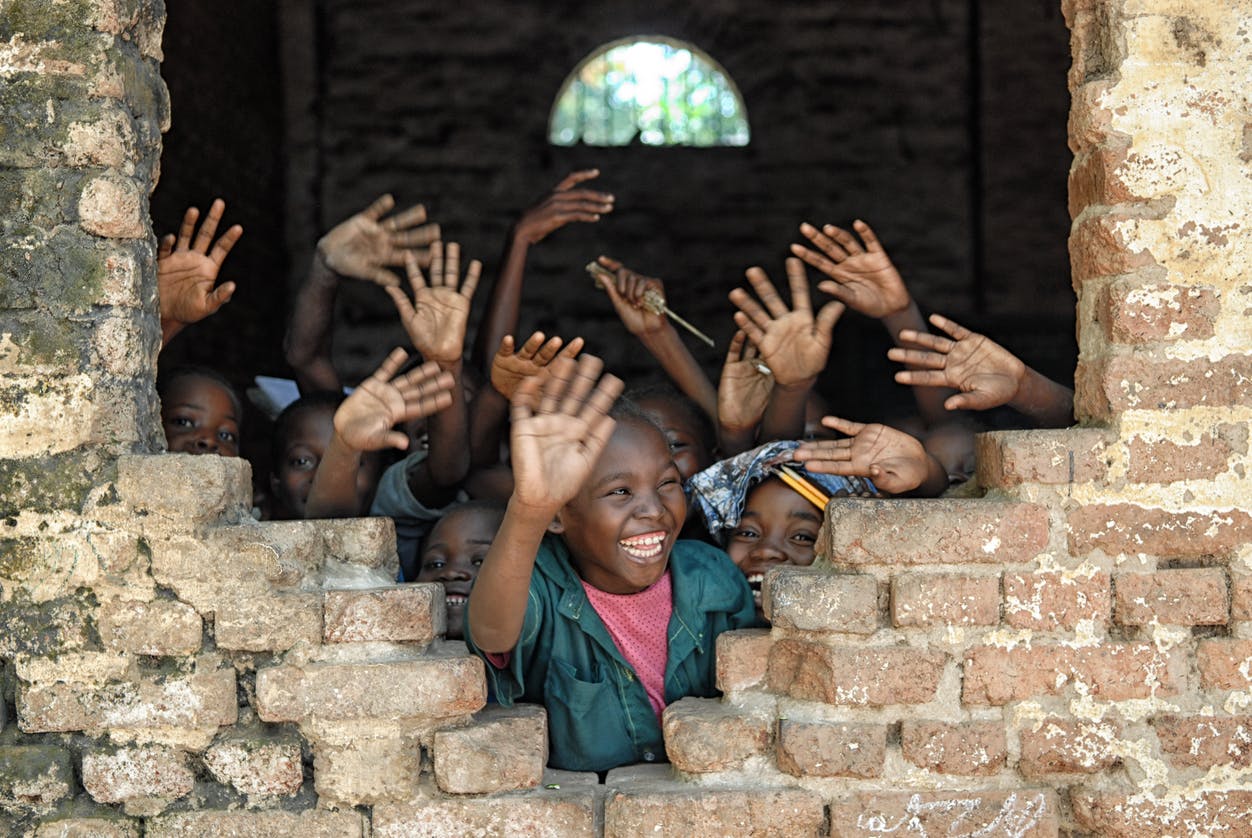 children waving in school window